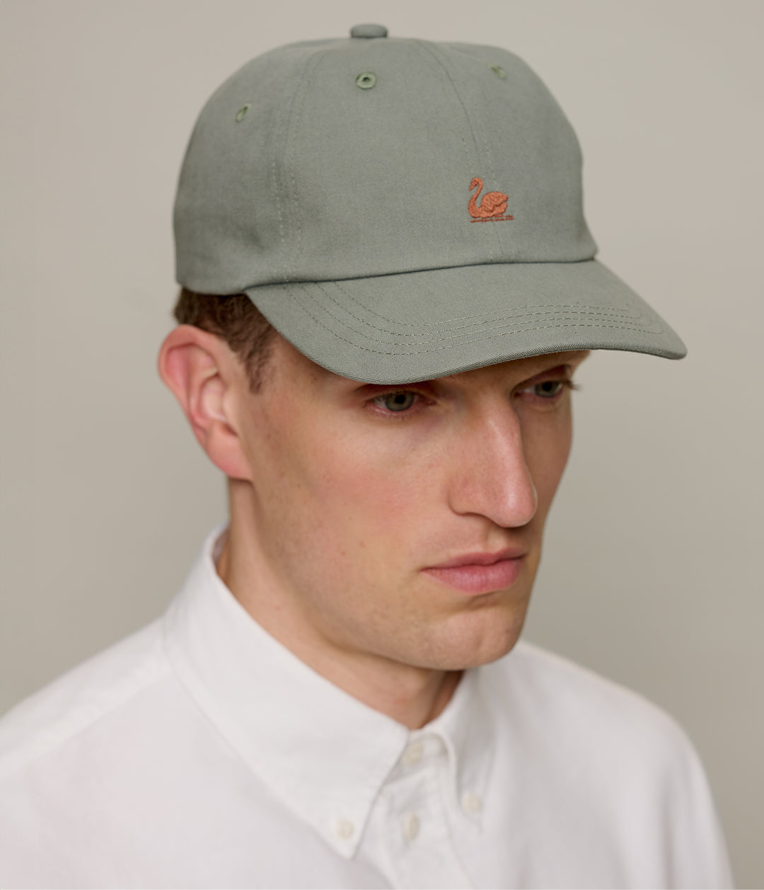 Light army cotton twill cap with Swan logo by Merz b Schwanen, featuring a classic baseball cap style and adjustable strap.