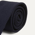 Dark navy large knot Grenadine handrolled tie by Drake's, showcasing its textured fabric and classic knot style.