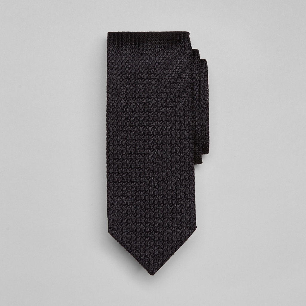 Large knot Grenadine handrolled tie in black from Drake's, showcasing its elegant texture and classic design for formal accessories.