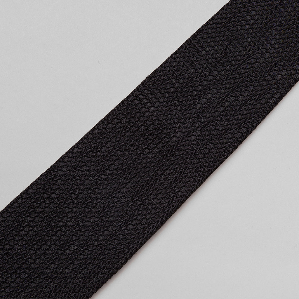 Black large knot Grenadine handrolled tie from Drake's, showcasing its textured fabric and elegant knot design.