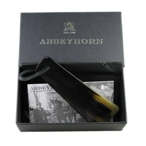 Abbeyhorn 4-inch travel shoehorn with leather thong, made of smooth horn, designed for easy shoe fitting and portability.