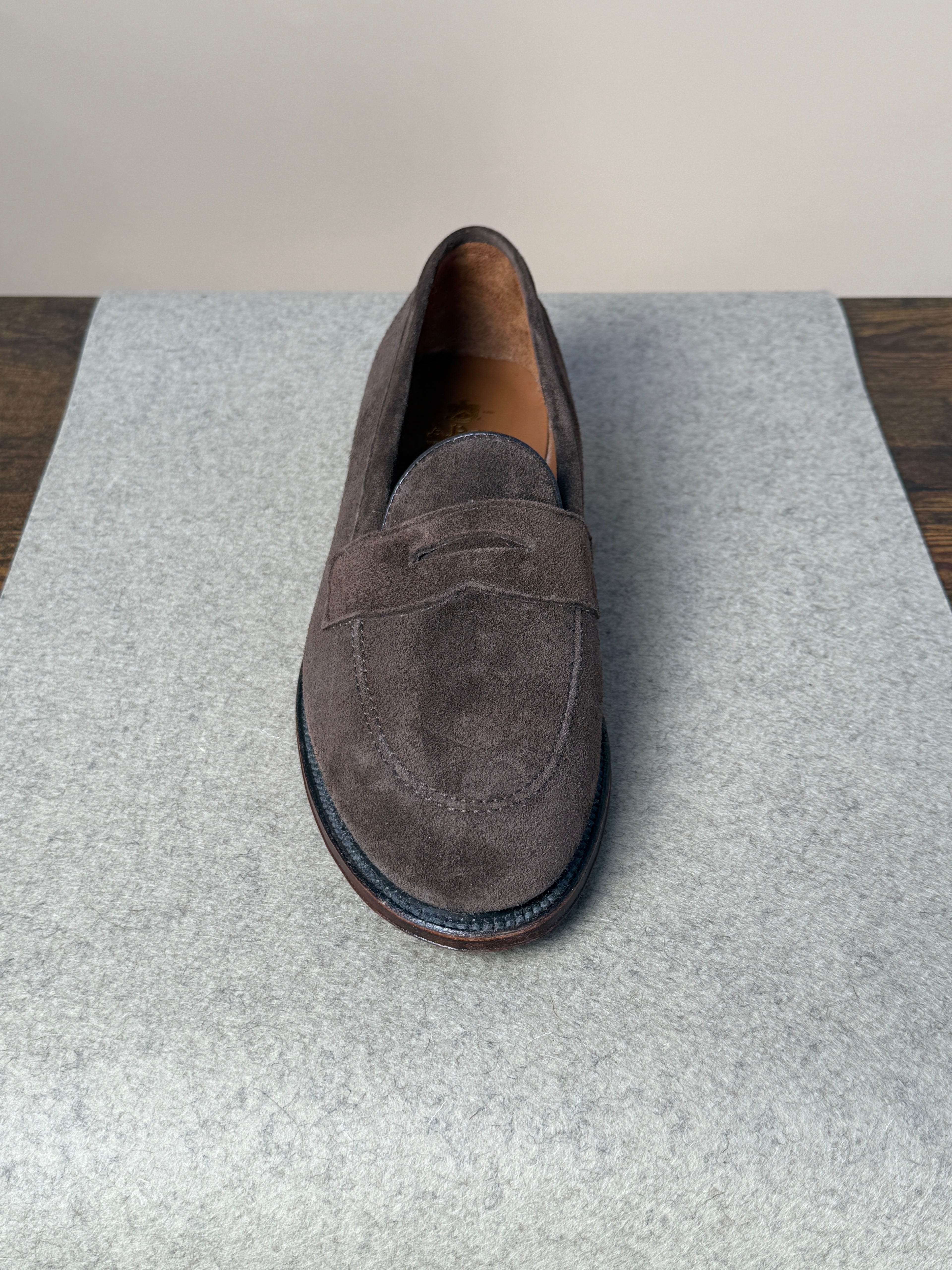 Alden Copley Penny Loafer in dark brown suede, showcasing a classic slip-on footwear design with smooth stitching and polished look.