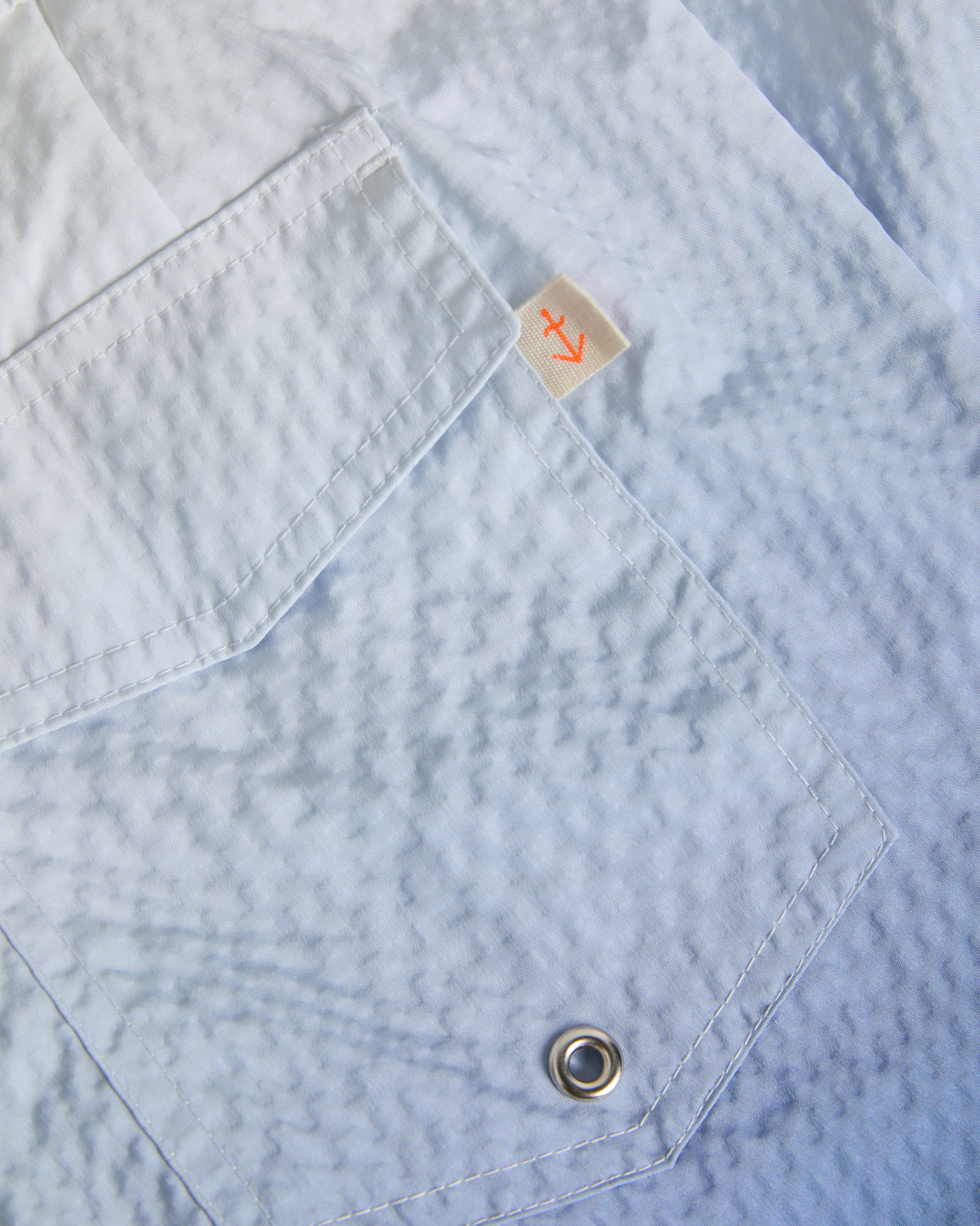 La Paz Fontes seersucker swimsuit in off-white and blue with adjustable straps and ruffled neckline, perfect for summer beachwear.