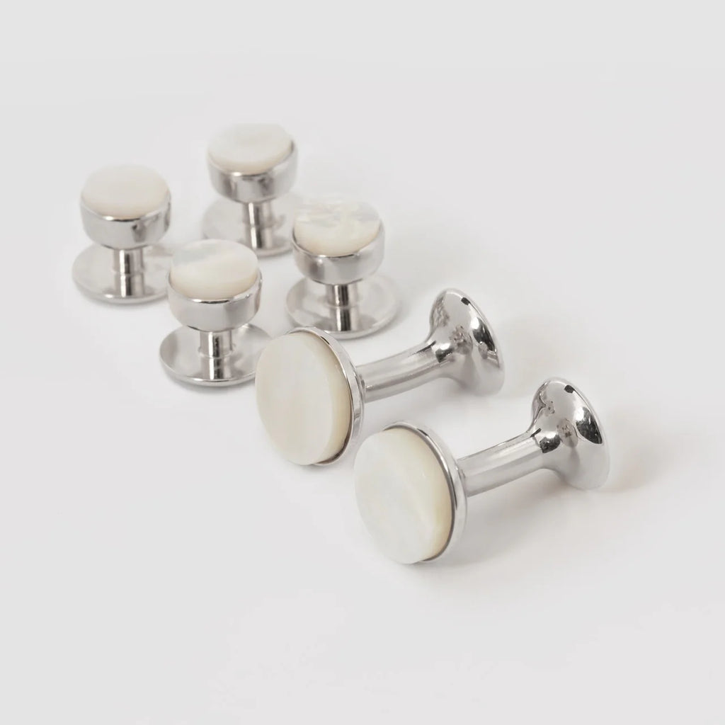 Mother of pearl and rhodium bow stud earrings by Codis Maya, elegant silver accessories with a sleek bow design.