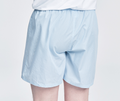 Light blue håndværk boxer shorts hanging on a wooden hanger, showcasing the soft fabric and comfortable fit.