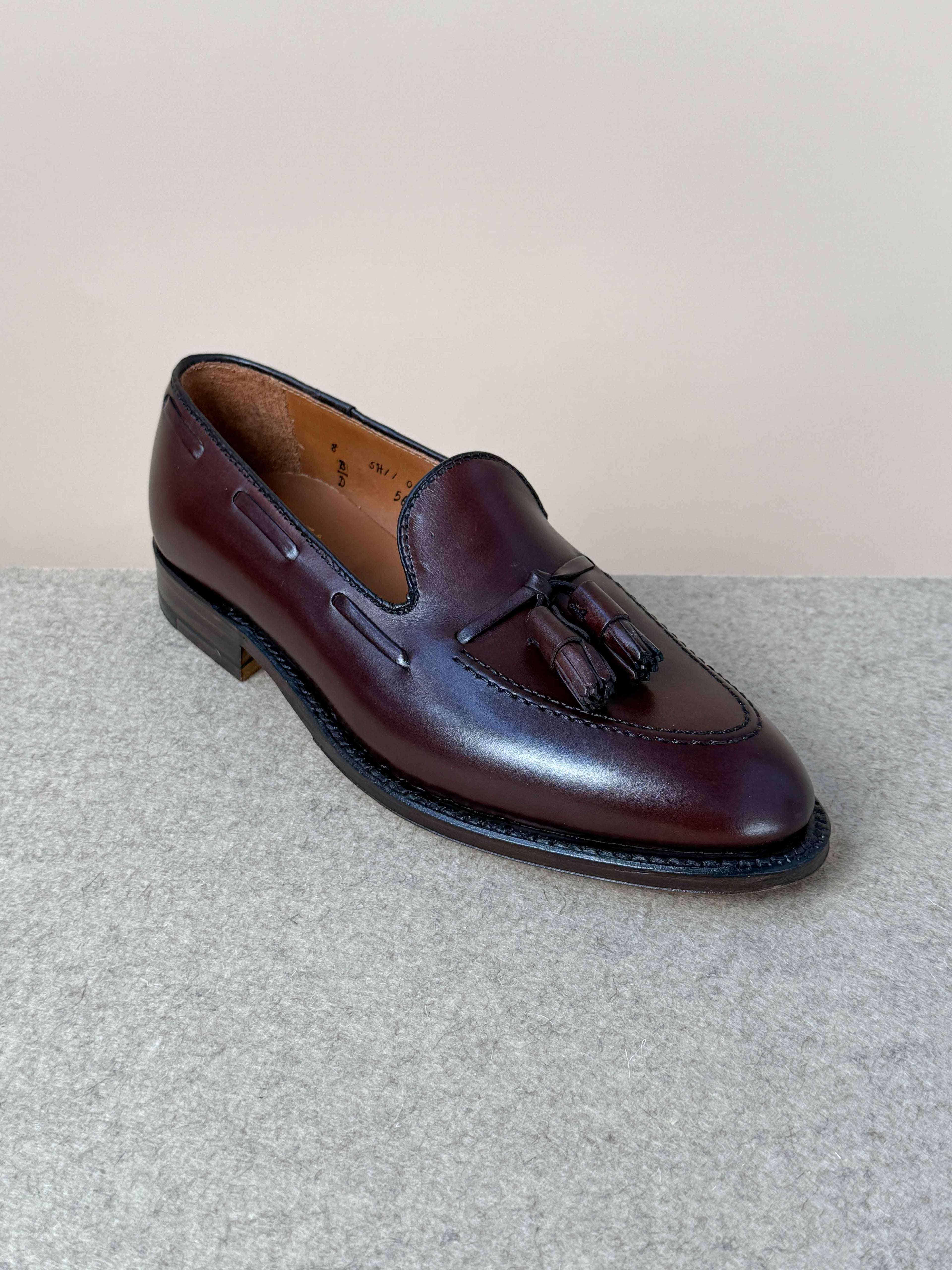 Dark brown calfskin tassel loafers by Alden, showcasing sleek, classic men's footwear with detailed tassel accents.