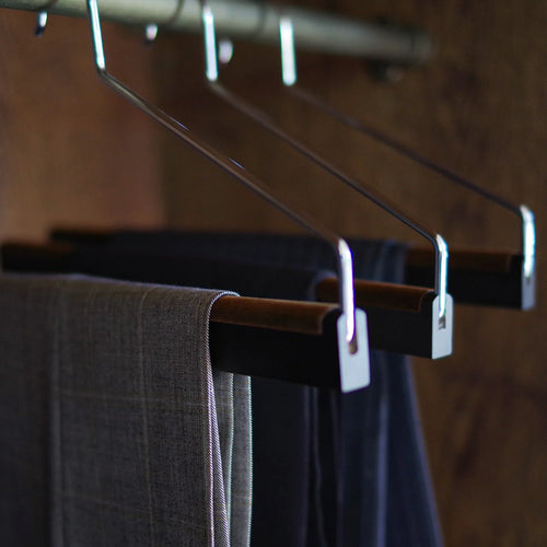 Nakata Hanger preordered trouser hanger hanging on a wardrobe rod, showcasing durable metal clips and sleek design for clothing organization.