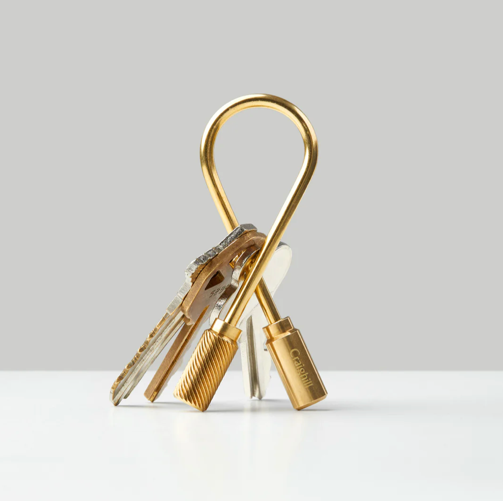 Brass Closed Helix Keyring by Craighill, a stylish accessory with a sleek, twisted design for holding keys.