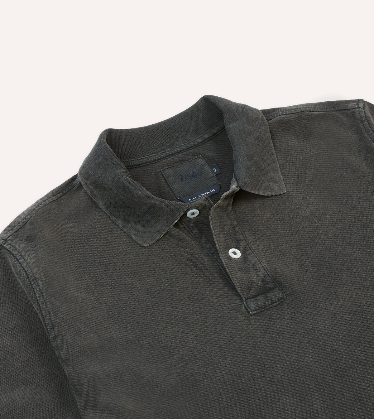 Drake's Piqué Cotton Polo in washed black, showing a classic collared shirt with textured fabric and button front.