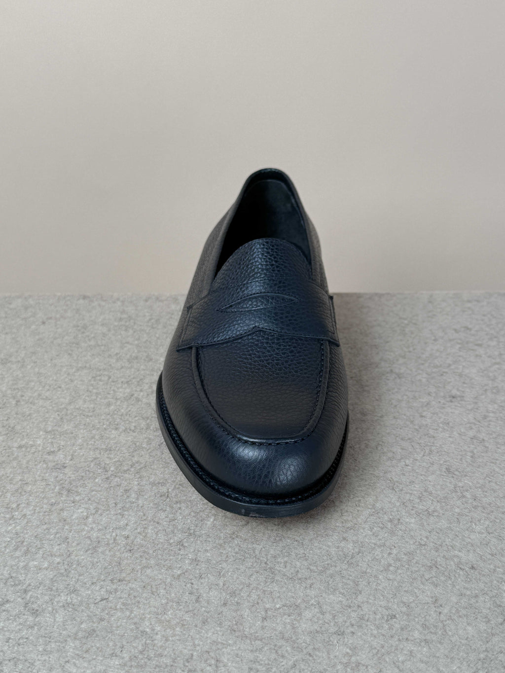 Edward Green Pimlico Penny Loafer in black Cotswold grain leather, showcasing classic slip-on footwear with sleek stitching details.