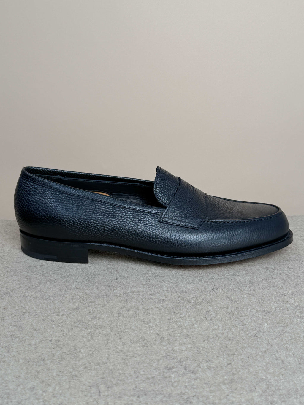 Edward Green Pimlico Penny Loafer in black Cotswold grain leather, showcasing classic slip-on footwear with sleek stitching details.