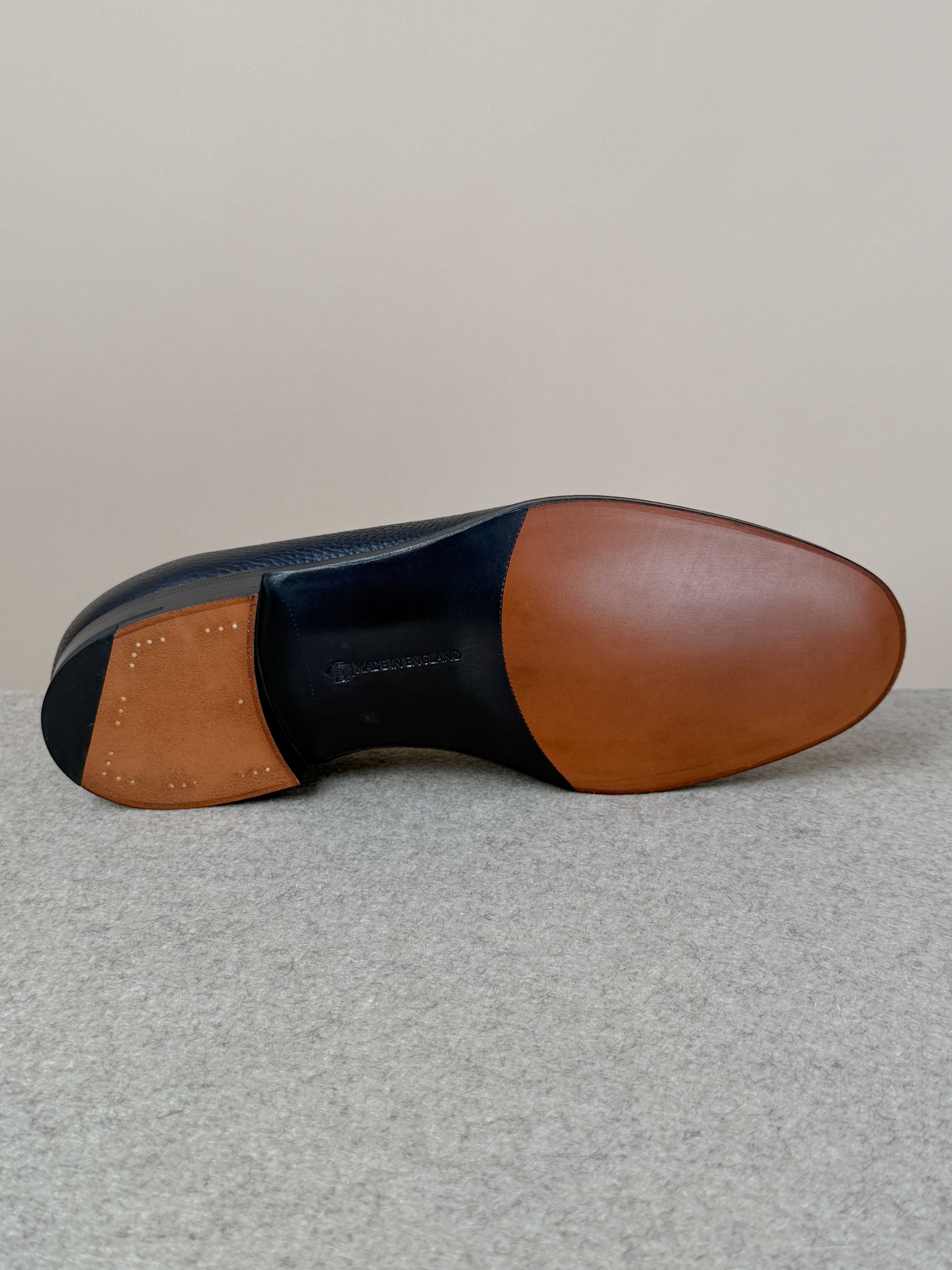Edward Green Pimlico Penny Loafer in black Cotswold grain leather, showcasing classic slip-on footwear with detailed stitching.