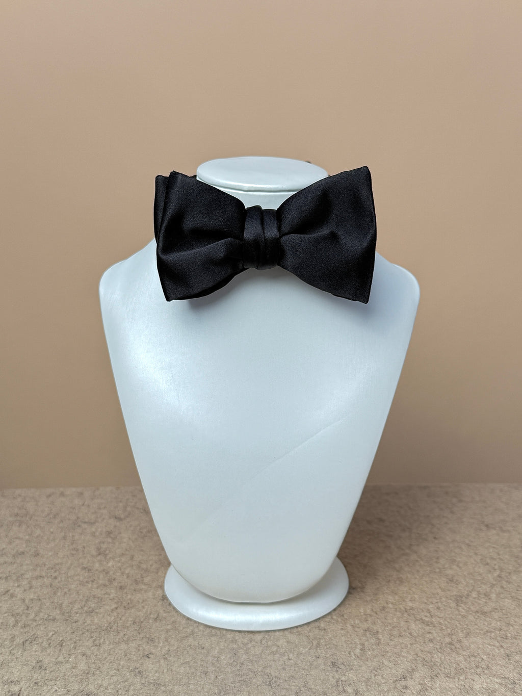 Black silk satin medium batwing bow tie from La Bowtique, showcasing its elegant shape and smooth satin finish.