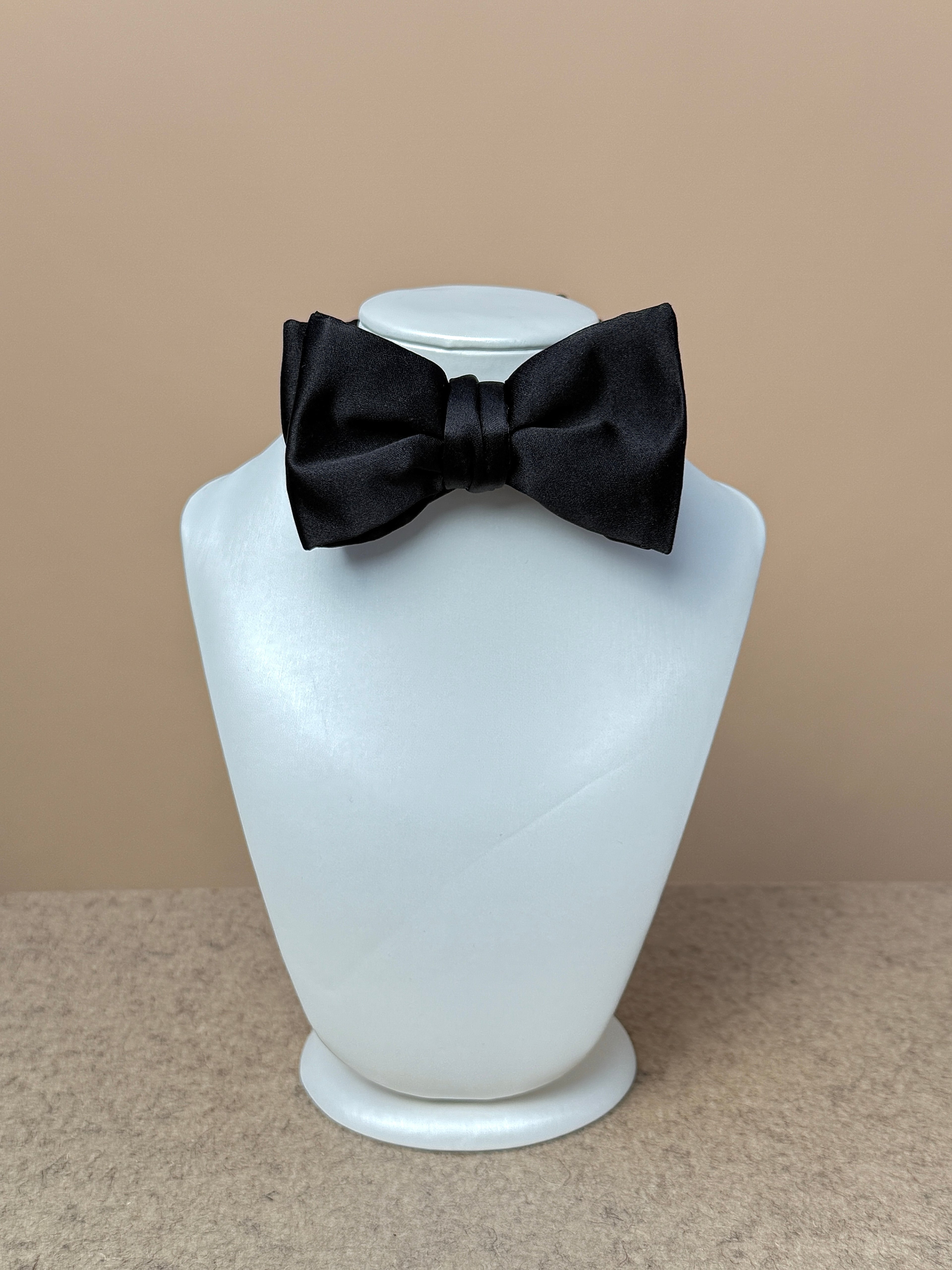 Black silk satin medium batwing bow tie from La Bowtique, showcasing its elegant shape and smooth satin finish.