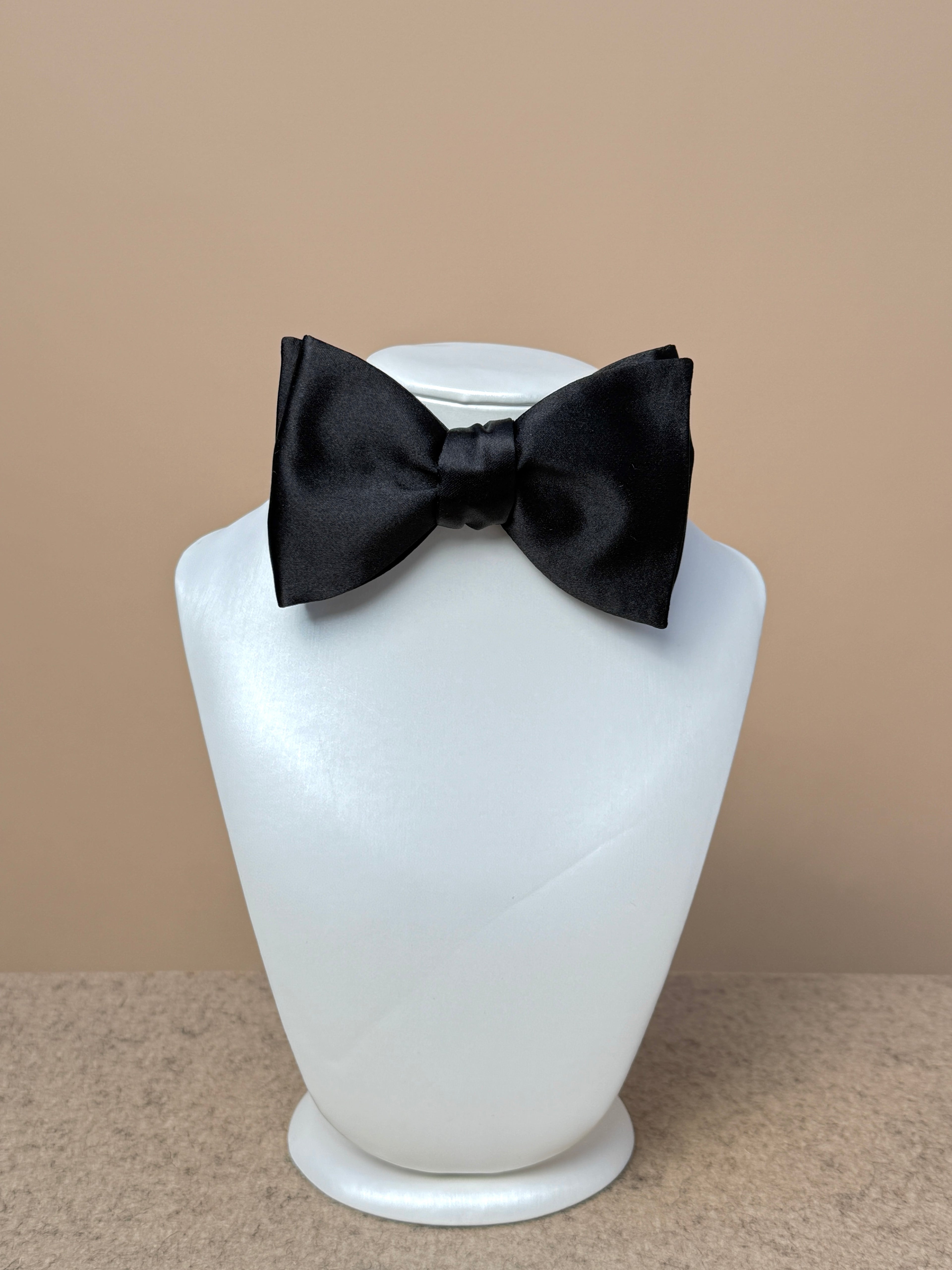 Black silk satin medium classic bow tie by La Bowtique, featuring a sleek and elegant accessory for formal occasions.