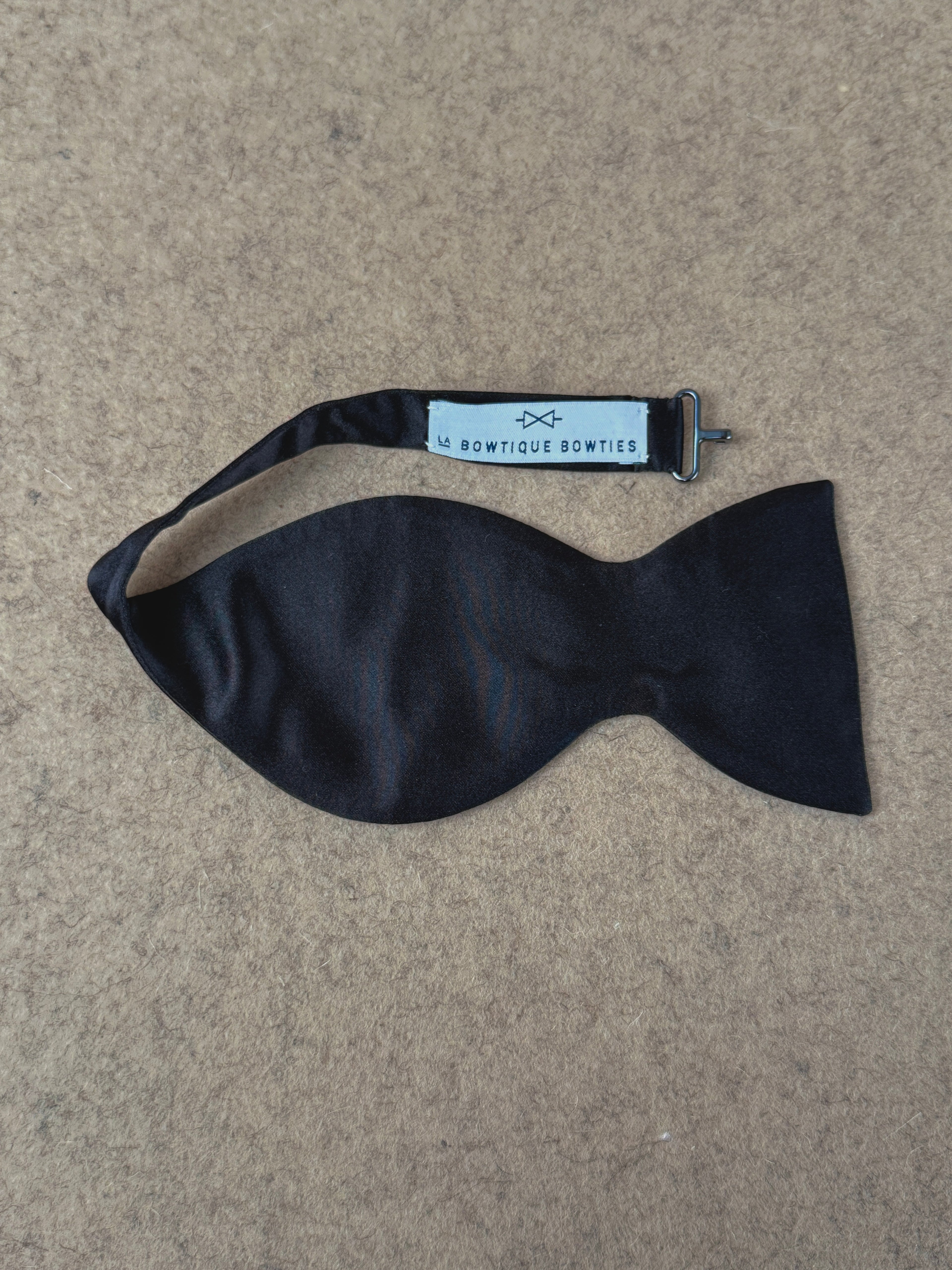 Black silk satin Crompton medium dropped bow tie from La Bowtique, showcasing its elegant and stylish accessory design.