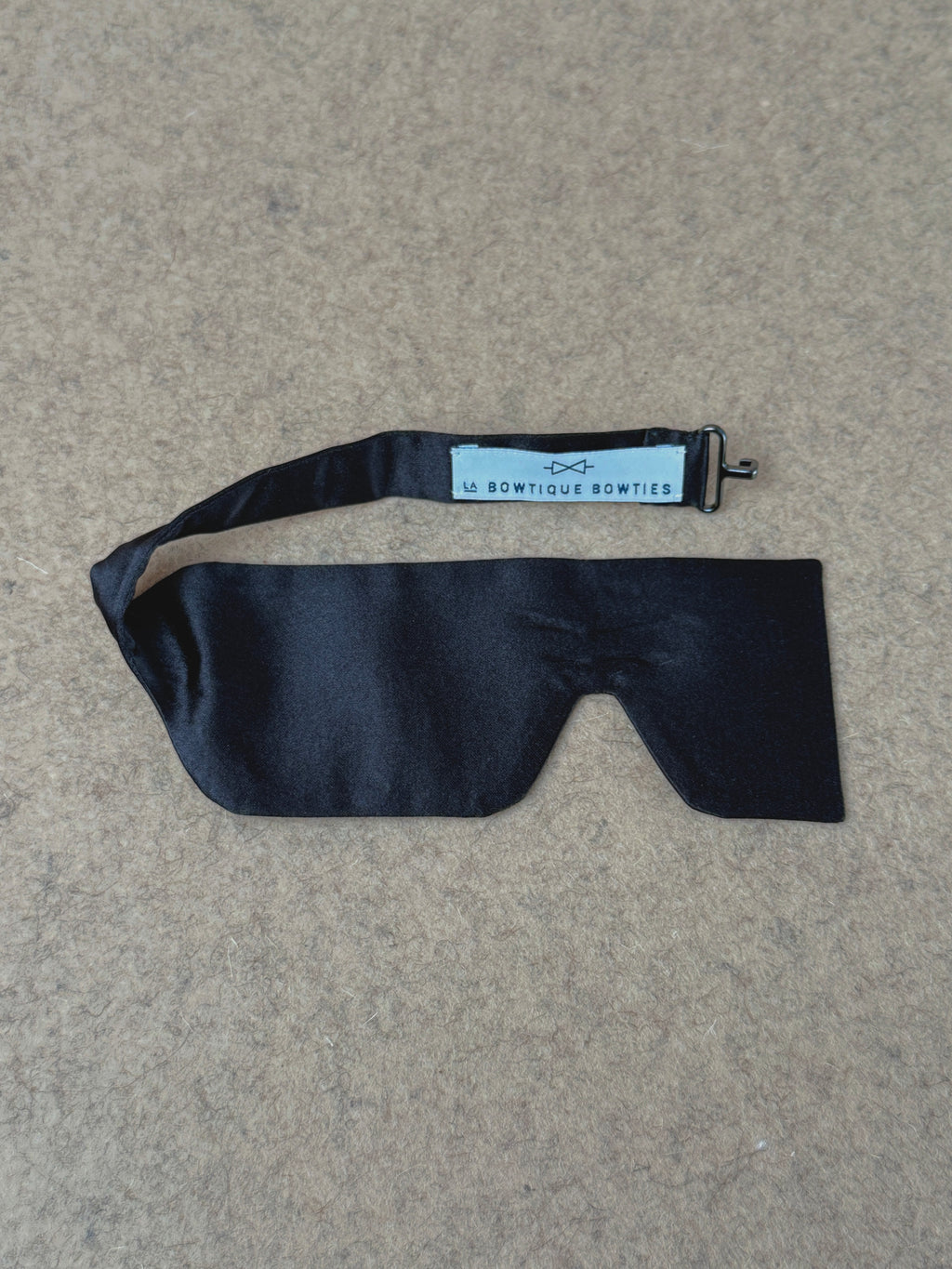 Black silk satin small Laurent bow tie from La Bowtique, showcasing its elegant and smooth fabric with a classic bow shape.