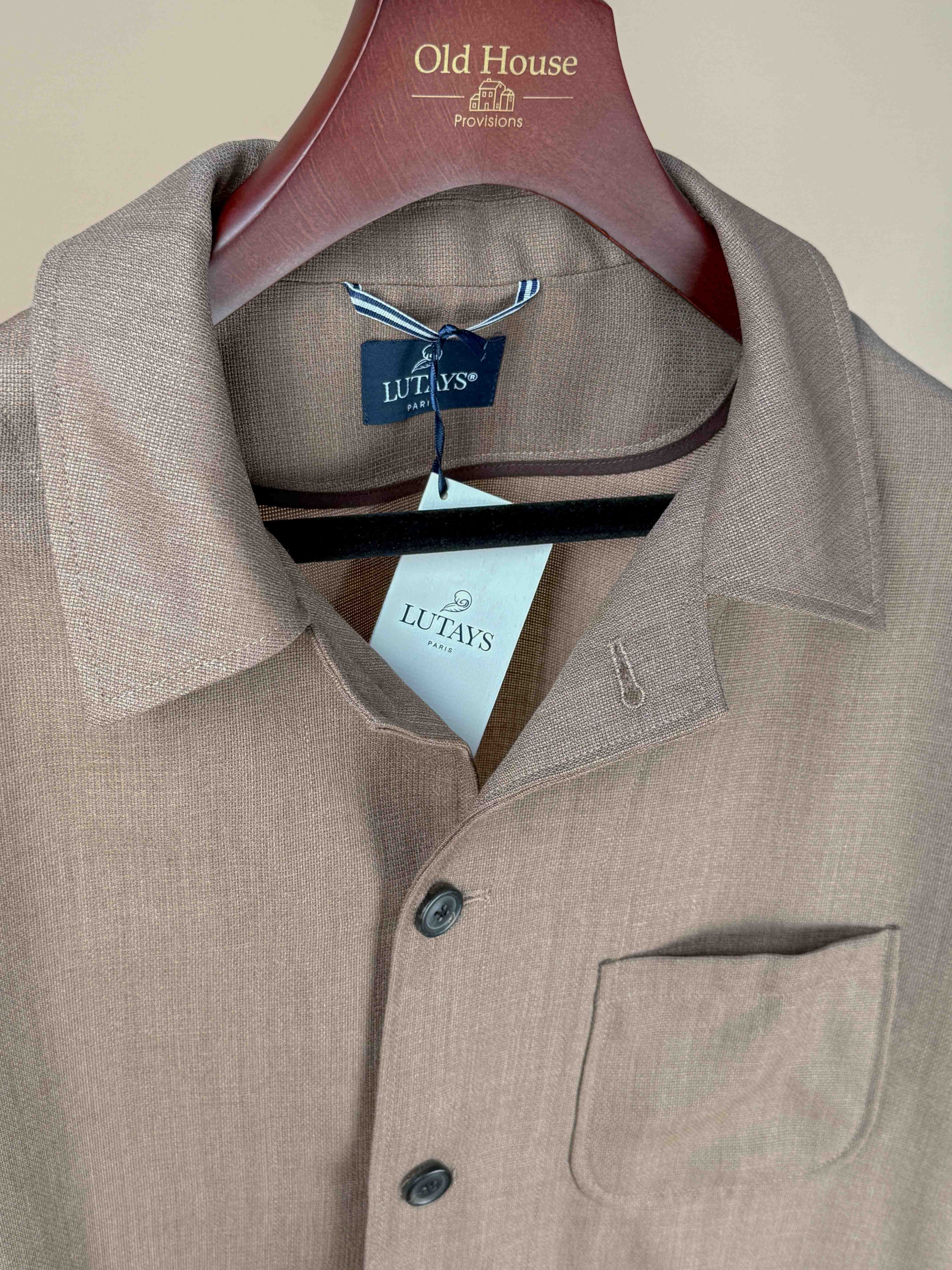 Lutays Zola unlined beige wool mohair hopsack jacket displayed on a hanger, showcasing its lightweight, textured fabric and tailored fit.