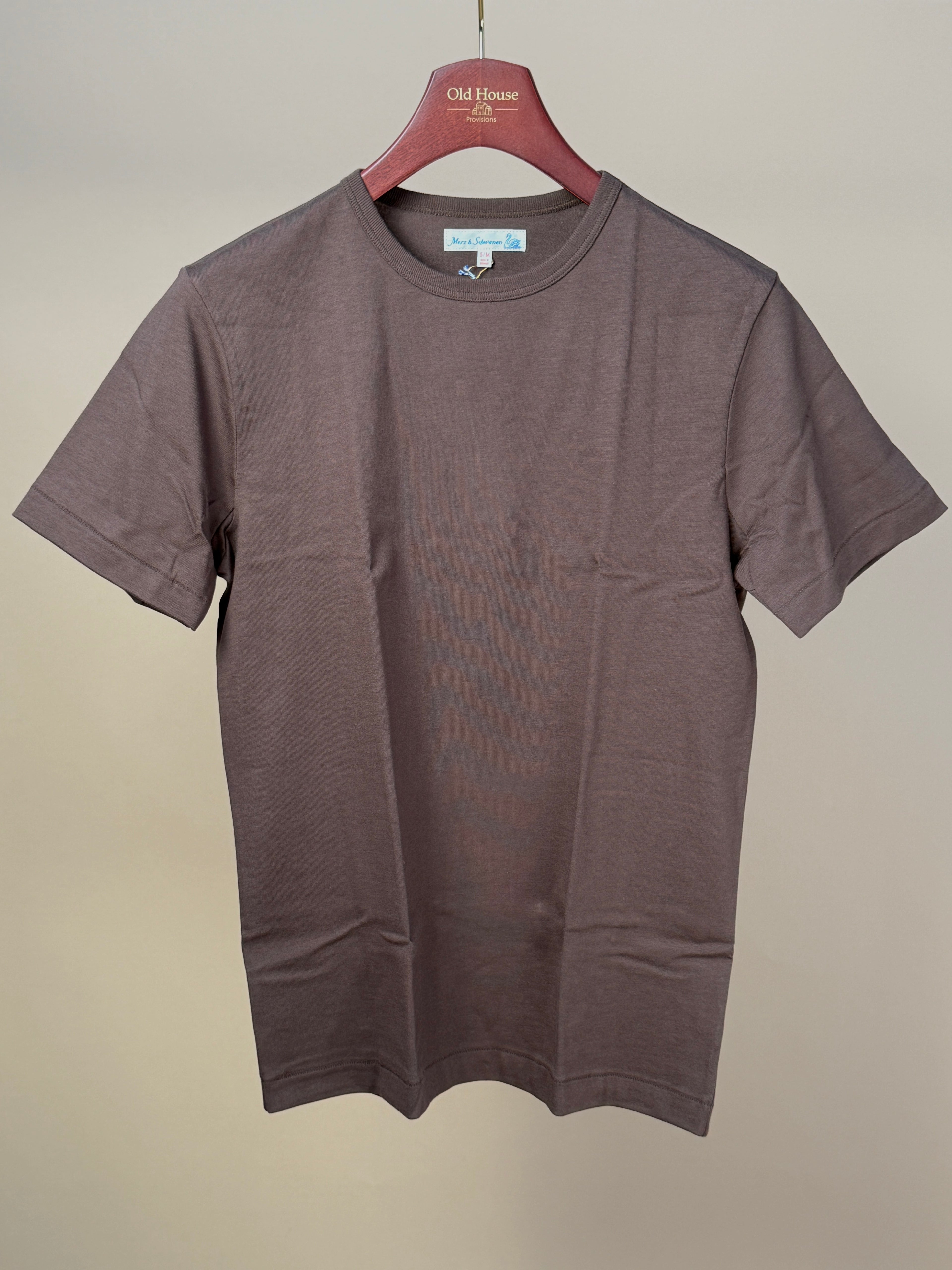 Chocolate Merz b Schwanen 2M15 T-Shirt, soft cotton fabric, classic fit, visible neckline and chest logo in the image.