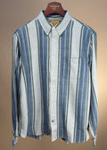 Broken twill button-down shirt in blue, green, and gray stripes by Original Madras Trading Co. displayed on a hanger.