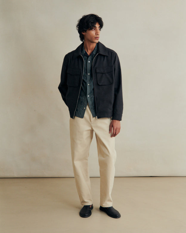 De Bonne Facture anthracite wool student jacket featuring a Prince of Wales check pattern on a hanger.