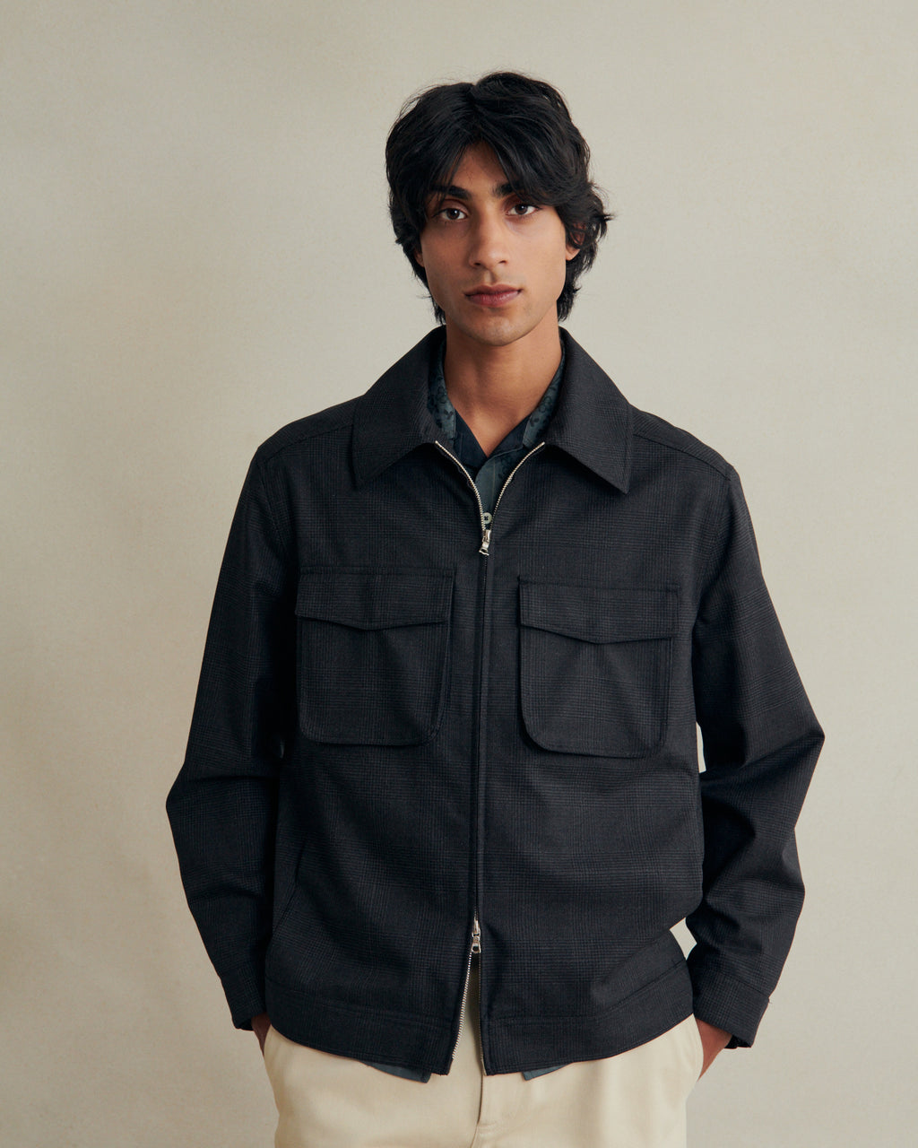 De Bonne Facture anthracite wool student jacket featuring a classic Prince of Wales pattern, displayed on a hanger.