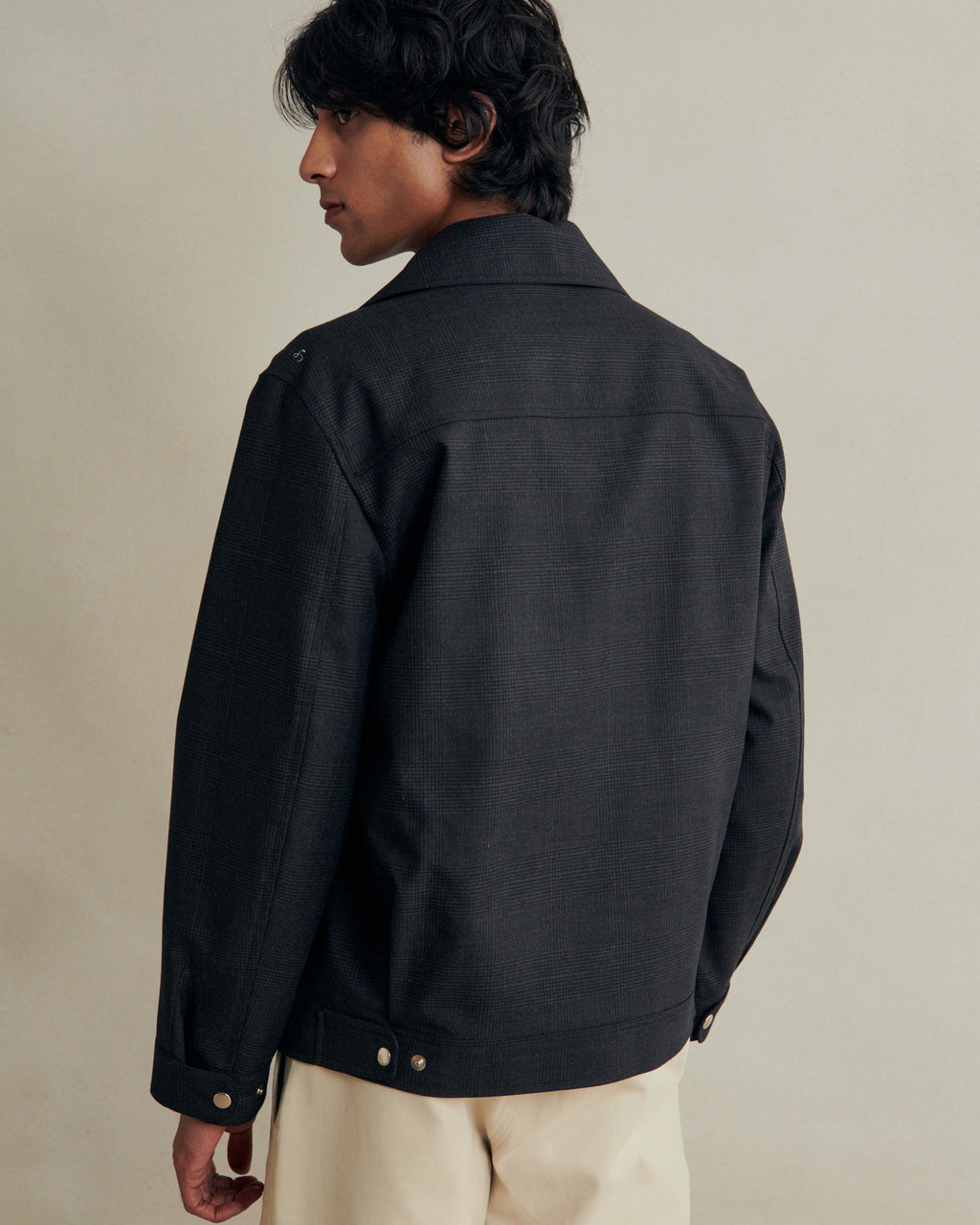 De Bonne Facture anthracite prince of Wales wool student jacket displayed on a hanger, showcasing its classic design.