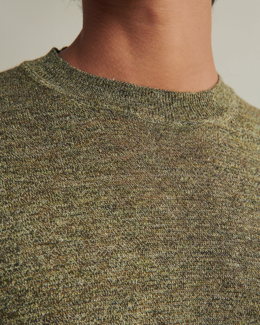 Green linen knitted tee by De Bonne Facture, showing the textured fabric and classic fit on a hanger.