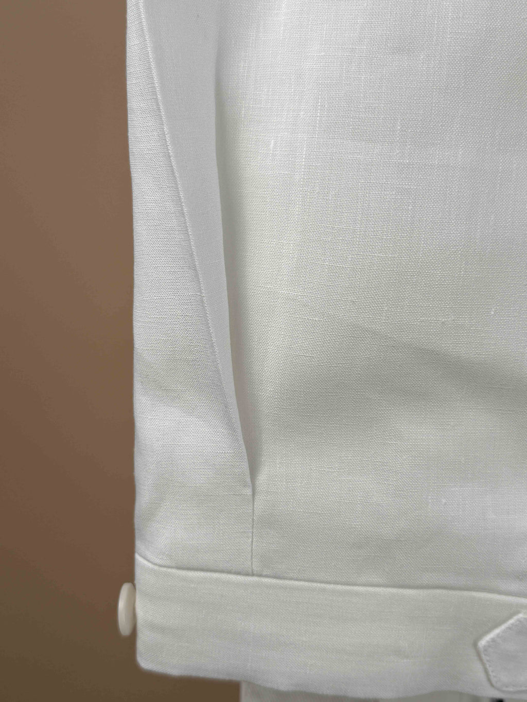 White linen pleated dress trousers by Rota, showcasing the tailored fit and classic style on a model.
