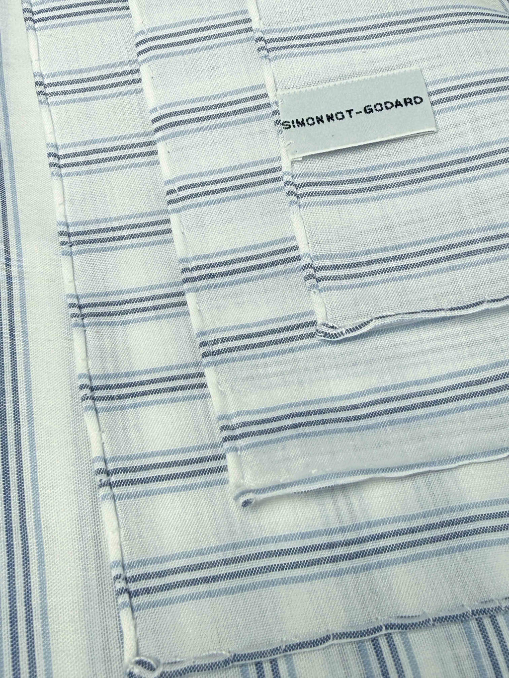 White, blue, and navy striped cotton pocket square from Simonnot-Godard's Archive collection, featuring a classic folded design.