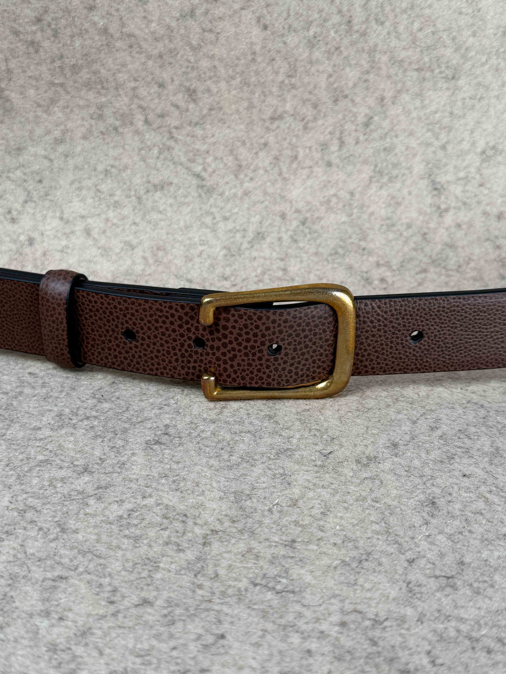 Brown Pebble Grain Spur Belt by Simonnot-Godard, showing textured leather strap with silver buckle detail.