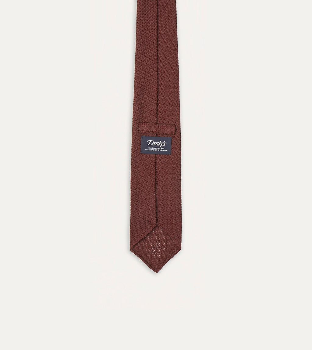 Large Knot Grenadine handrolled tie in wine color from Drake's, showcasing its textured fabric and classic knot style.